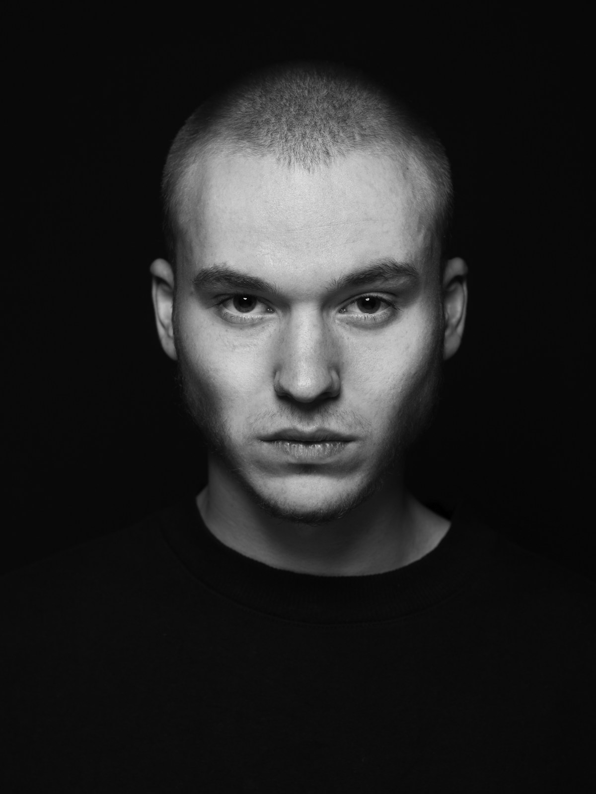 A dramatic low-key portrait of a single subject against black